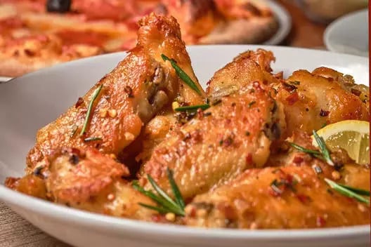 A bowl of Bertucci's Twice-Baked Brick Oven Tuscan Chicken Wings marinated in lemon & rosemary