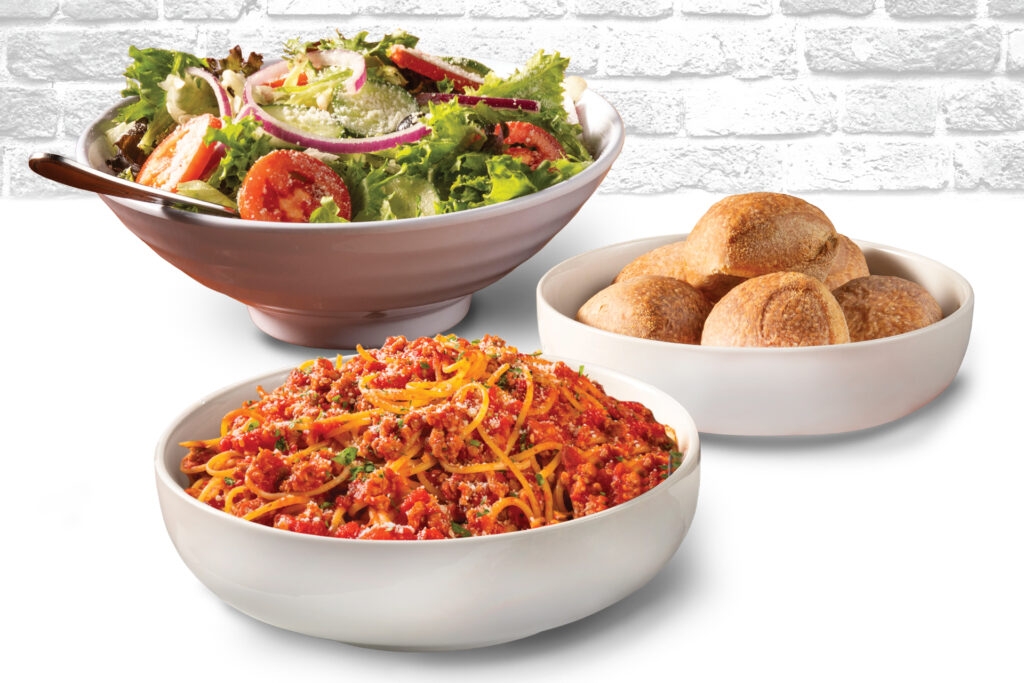 Bertucci's family bundle with spaghetti with meat sauce, a large bowl of salad, and rolls